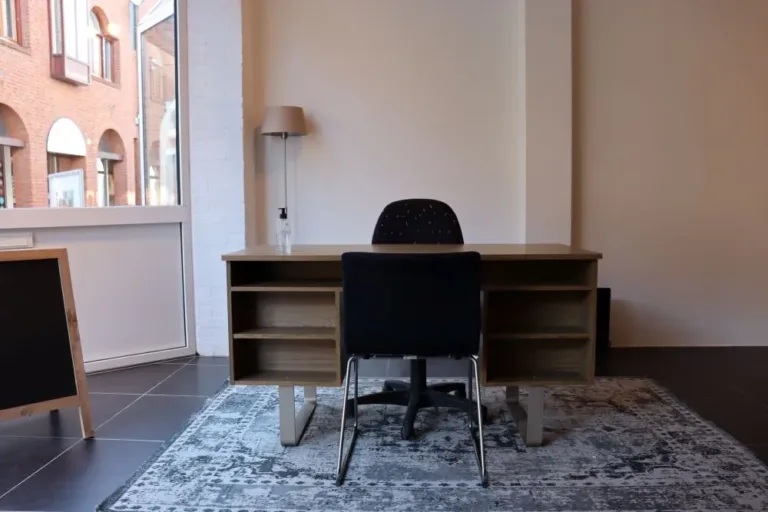 Een foto van een bureau met een bureau stoel die langs een raam staat