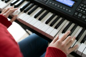 hand playing piano keyboard